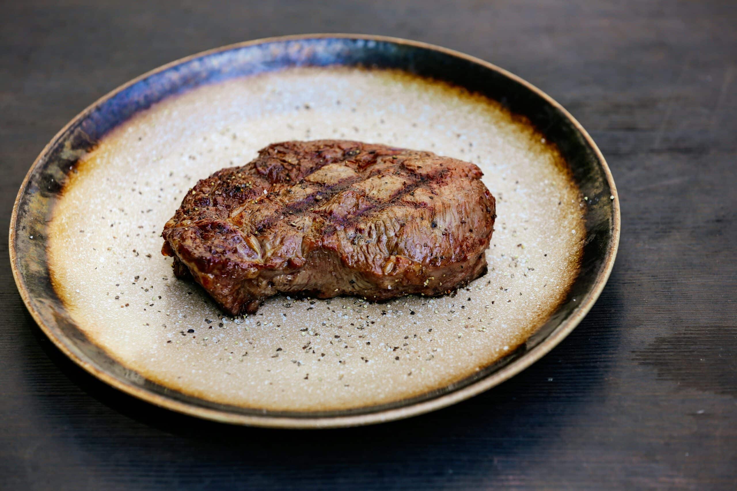 Steak de bœuf à l’herbe cuit à la poêle, servi sans sauce dans une assiette sobre, illustrant une alimentation saine et naturelle