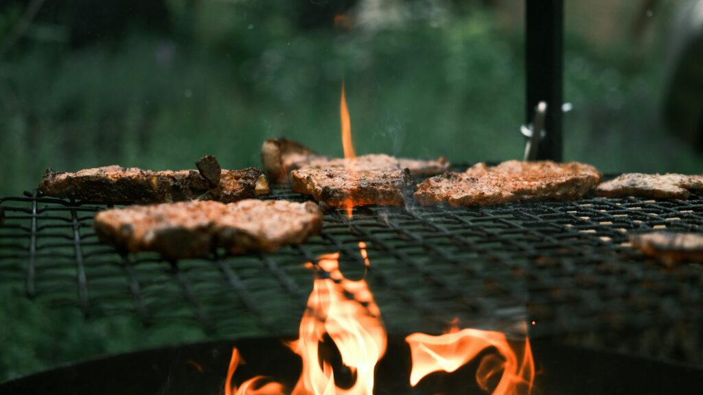 Viande grillée sur feu de bois, illustrant la cuisson traditionnelle du bœuf nourri à l’herbe